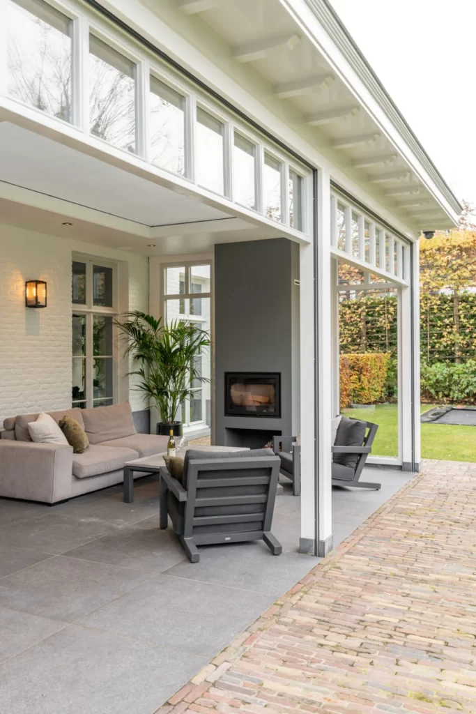 Hardhouten veranda met sfeervolle inrichting en open haard
