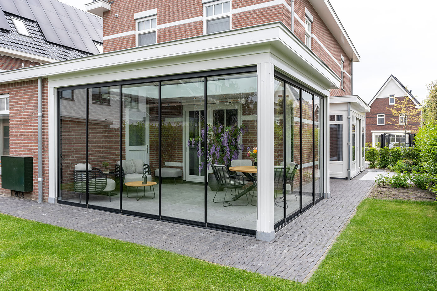 Veranda met glazen schuifwanden bij klassieke woning in Den Haag