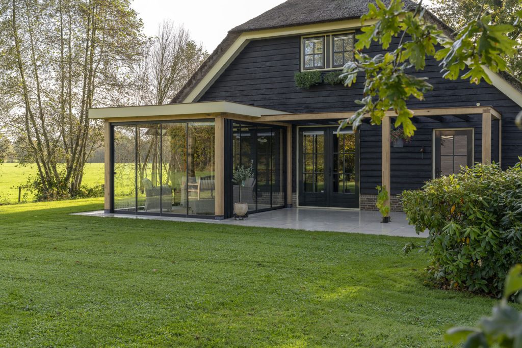 Landelijke terrasoverkapping met glazen schuifwanden
